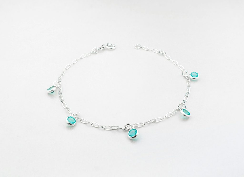 a silver bracelet with turquoise beads and charms